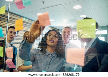 Young black businesswoman explaining business strategy to the staff in the office. Mixed team of entrepreneurs brainstorming  Royalty-Free Stock Photo #626268179