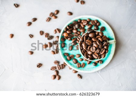 Vintage coffee mug with raw coffee beans on dark rustic wooden background