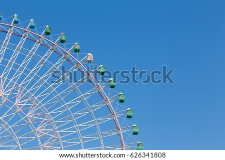 Part of big funfair ferris wheel with clear blue sky background