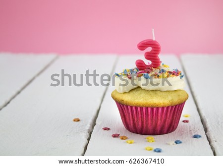 Happy birthday cup cake with star sprinkles and number 3 pink candle on white tabel with pink background - Birthday celebration background for a little girl Royalty-Free Stock Photo #626367410
