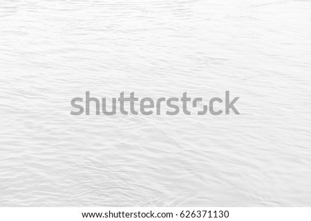 Background light gray water surface. Small waves on water, black and white background