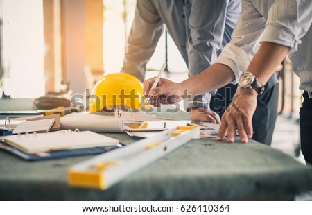 Two business man construction site engineer. Engineering objects on workplace with partners interacting on background Royalty-Free Stock Photo #626410364