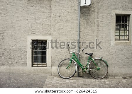 Vintage green bicycle parking on the street at the pole in Europe, Environmental friendly transportation