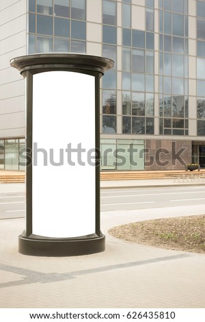 Advertising column mockup. Blank public information board mock up in front of the modern architecture building with glass windows