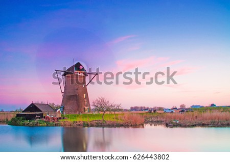 Magic fascinating picture of beautiful windmills spinning at dawn in Kinderdijk, Netherlands, Europe.