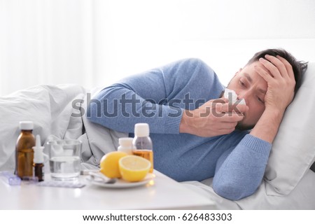 Young ill man lying in bed at home Royalty-Free Stock Photo #626483303
