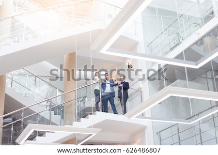 Business team, businesspeople group at modern bright office interior. Young and stylish business man and woman with laptop talking at break on workplace Royalty-Free Stock Photo #626486807