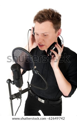 Young man singing song to microphone in studio on white background