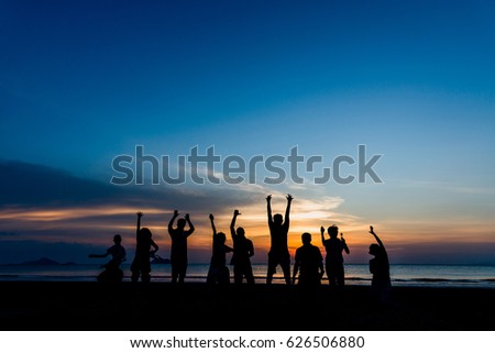 Silhouette group of people jumping on the beach at golden sunset time, Hello summer concept