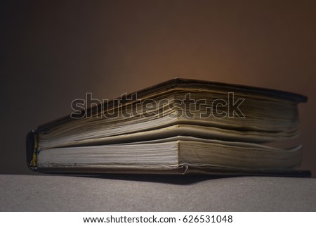  small book on a dark background, lies on a table.