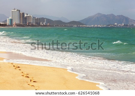city beach and beautiful waves with a view of the skyscrapers