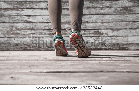 female legs in tights and sports shoes on wooden background ,concept sports