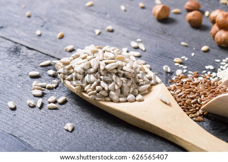 nuts and cereal seeds on black wood table background
