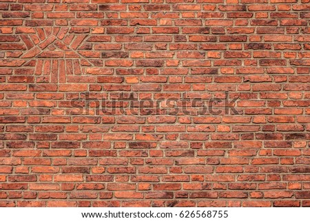 Background of old red vintage brick wall and all-seeing eye made of bricks. Abstract orange-red brick wall pattern and symbol all-seeing eye. Triangle, eye and beams are associated with the Illuminati