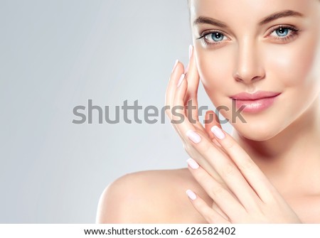 Beautiful Young Woman with Clean Fresh Skin  touch own face . Facial  treatment   . Cosmetology , beauty  and spa . Royalty-Free Stock Photo #626582402