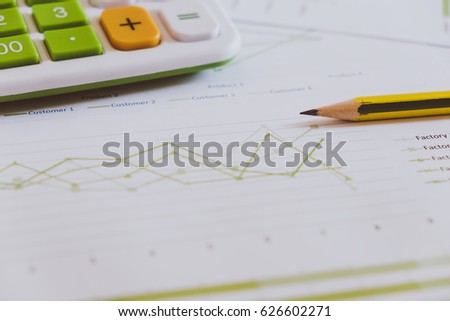 Many charts and graphs with pencil and calculator. Reflection light and flare. Concept image of data gathering and statistical working.
