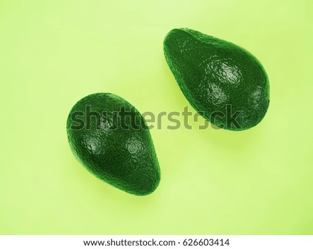 Two avocados on yellow green background. Art food concept