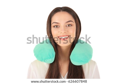 Beautiful young woman with travel pillow on white background