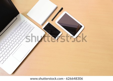 Computer notebook laptop with digital tablet and white smartphone on wooden desk. in business room