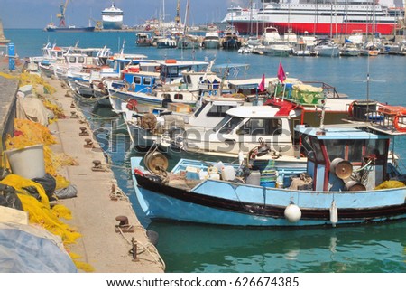View of fishing boats and fishing net on pier in port on a pleasure yacht and ferry background