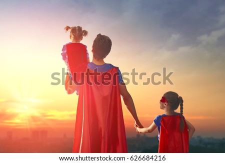 Happy loving family. Dad and his daughters are playing outdoors. Daddy and his children girls in an Superhero's costumes. Concept of Father's day. Royalty-Free Stock Photo #626684216