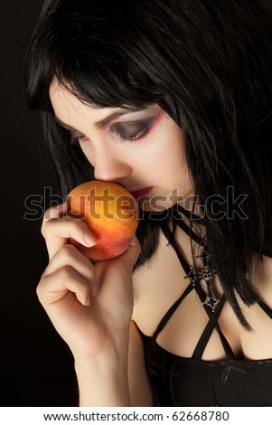Picture of woman with halloweeen make up smelling colorful peach