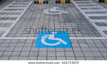 Handicapped disabled icon sign on parking area in car park.