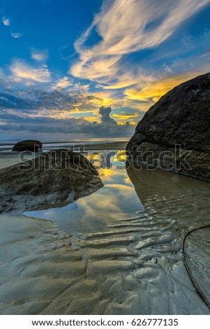 Beautiful A long exposure picture of sunrise over a sand beach