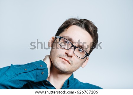 handsome man has a sore neck, isolated on a gray background