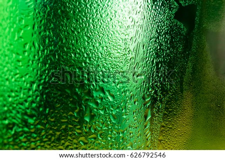 Water condensed on green glass surface abstract background.