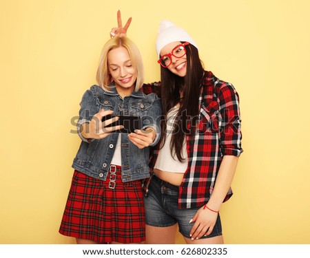 Happy girls  with smartphone  over yellow background. Happy self