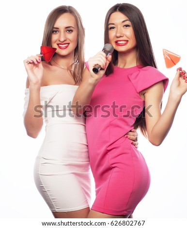  Happy girls friends with microphone and candy over white background