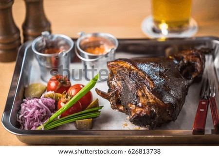 Pork knuckle, vegetables and sauce are a great choice for beer. Hot dish on the table close up. Healthy food.