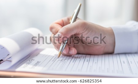 Applicant filling in company application form document applying for job, or registering claim for health insurance