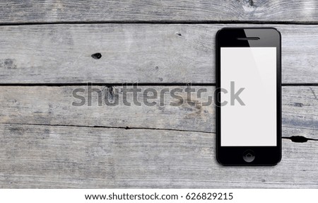 Black smartphone on old wood background texture with copy space