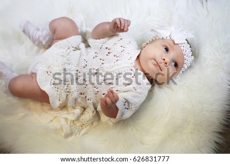 portrait of a beautiful baby girl in a white dress close-up