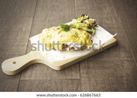 Picture of egg benedict cheese bun on the wooden table