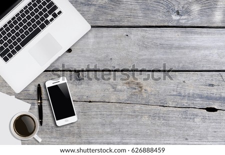 Place of work or work space. Close-up top view of comfortable working place with wooden table ,laptop ,smartphone, coffee cup,pen and paper