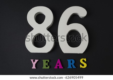 Letters and numbers eighty-six years on a black isolated background.