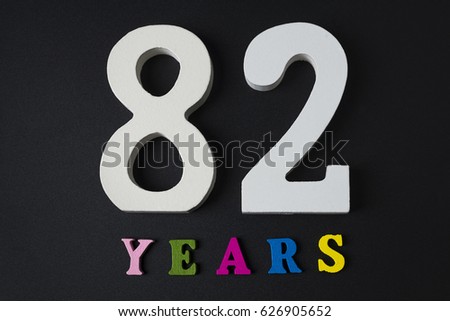 Letters and numbers eighty-two years on black isolated background.