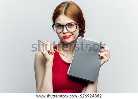 Woman with glasses with a notepad, woman knowledge, woman is pointing at a notepad