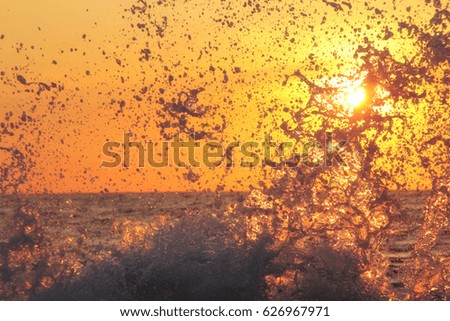 splash of sea wave at sunset. Counter light. Travel and business abstract background