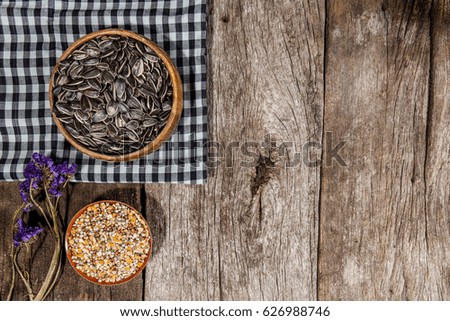 Beautiful mix corn and sunflower seeds in wooden bowl on wood table background , Top view.
