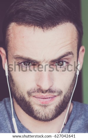 handsome, bearded guy with headphones listening to music