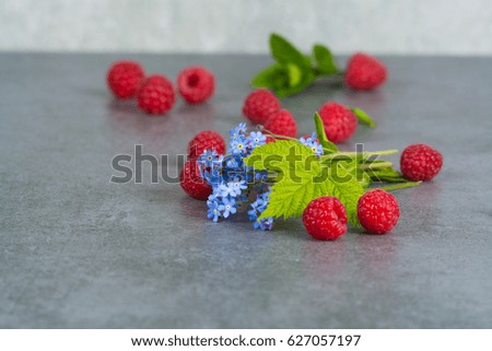 Sweet fresh raspberry with leaves, on grey background, copy space