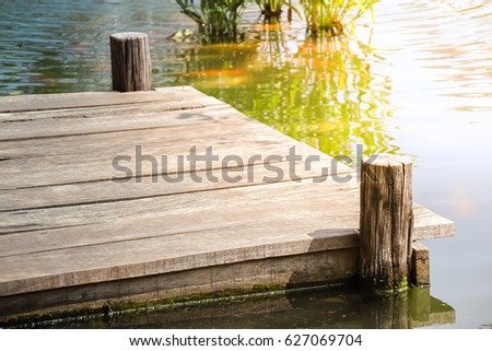 Wooden dock with sunlight on the lake Royalty-Free Stock Photo #627069704