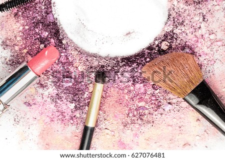 Closeup of a makeup brush, lipstick and pencil on a white background, with traces of powder and blush on it. A horizontal template for a makeup artist's business card or flyer design, with copy space