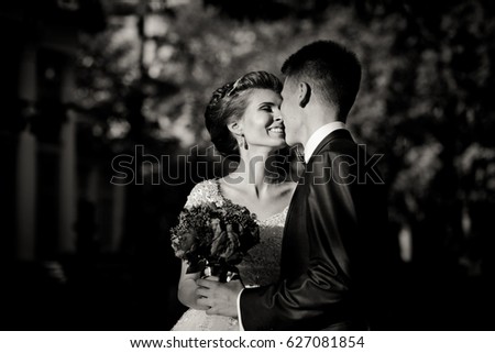 Black and white picture of wedding couple kissing in the sunny park