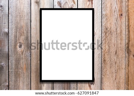 Mock up black wood frame with blank poster hanging on wooden wall in room