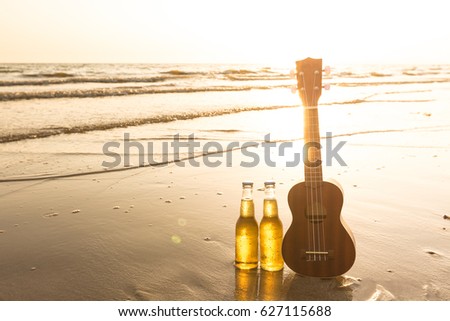 Beers and Ukulele lay down at beach and sea